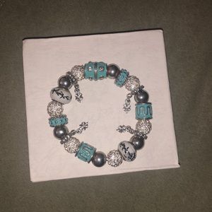 Elastic bracelet with white crystals and charms .